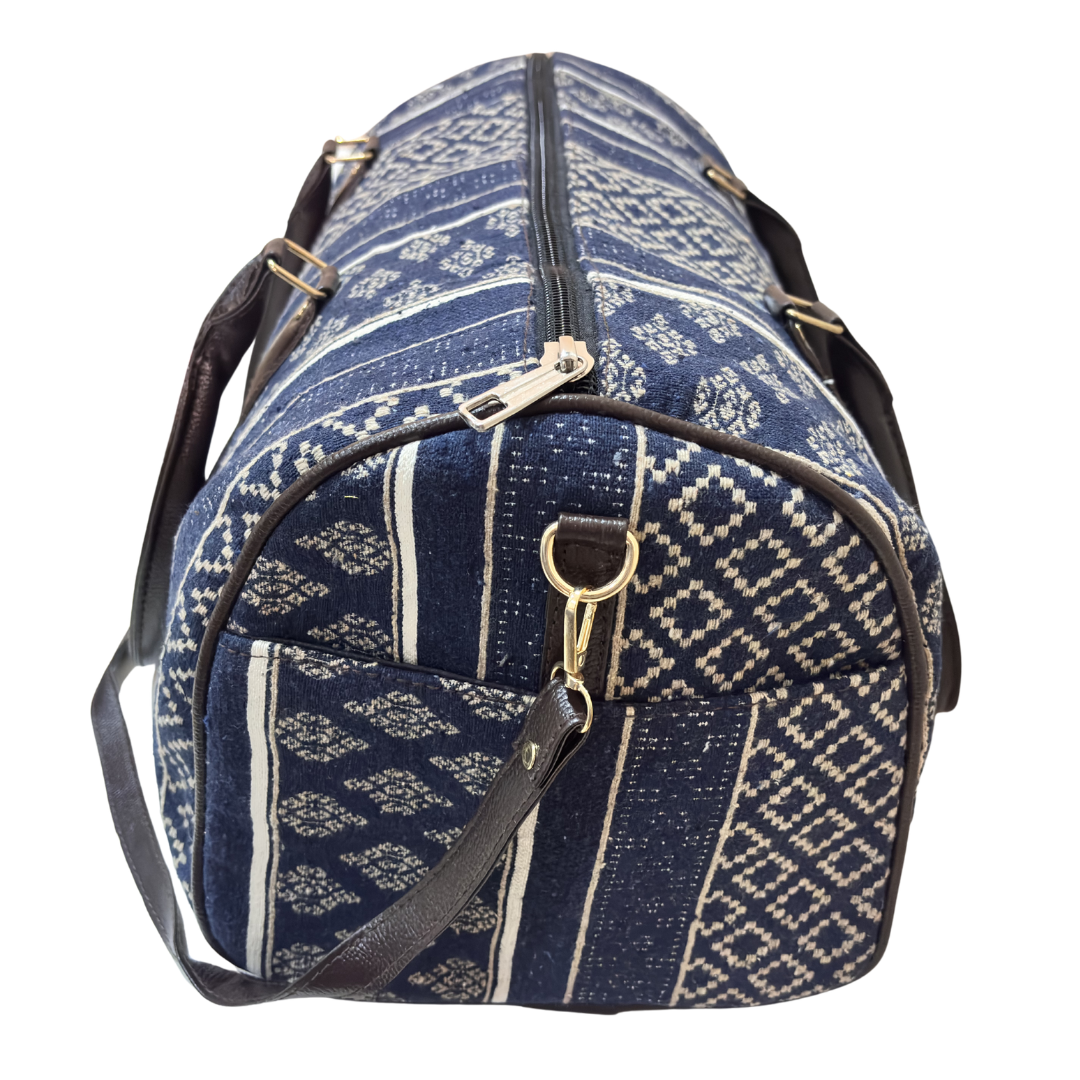 Riveted base of blue cabin-size cotton duffle — reinforced bottom for travel and gym use